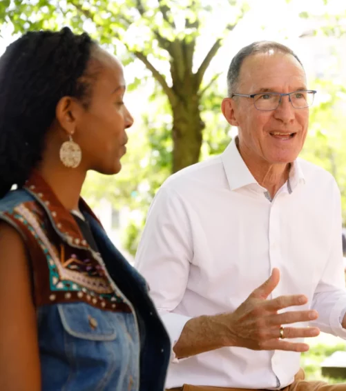 Carl having a conversation with a voter outside on a sunny day.